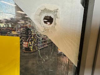 A bullet hole seen in the door of the CVS pharmacy in Atlanta where the gunman opened fire